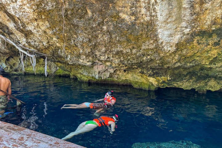 a group of people riding on the back of a boat in the water