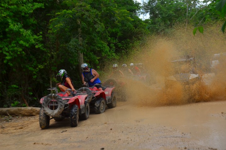 a man riding a motorcycle down a dirt road