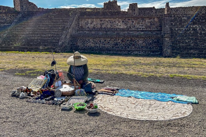 a person sitting in front of a stone building