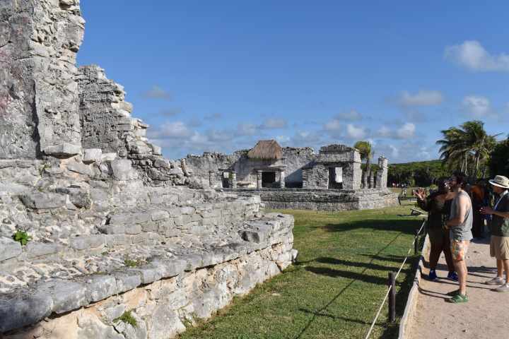 a group of people standing next to a stone wall