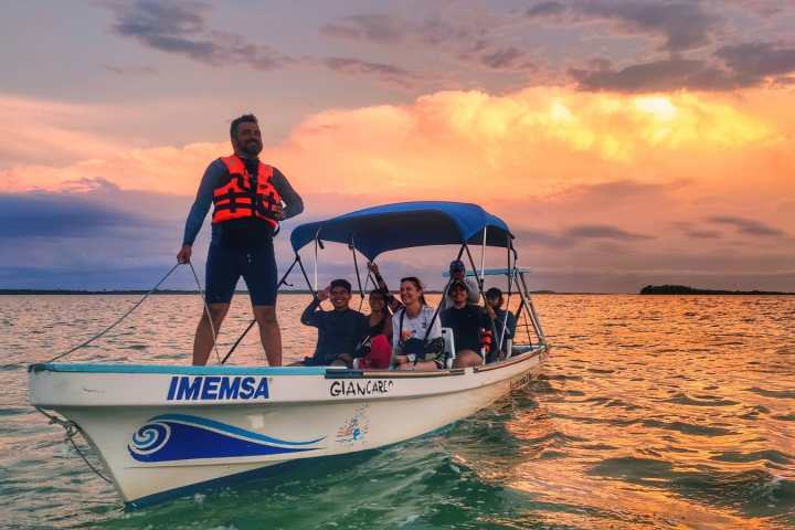 a man riding on the back of a boat in the water