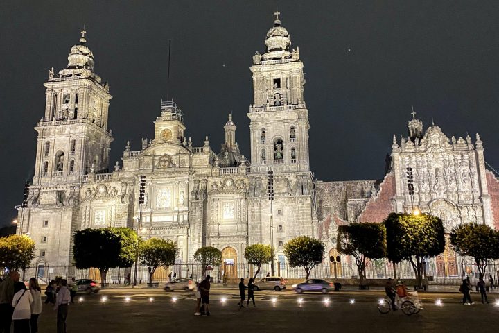 a group of people standing in front of a church with Plaza de Cibeles in the background