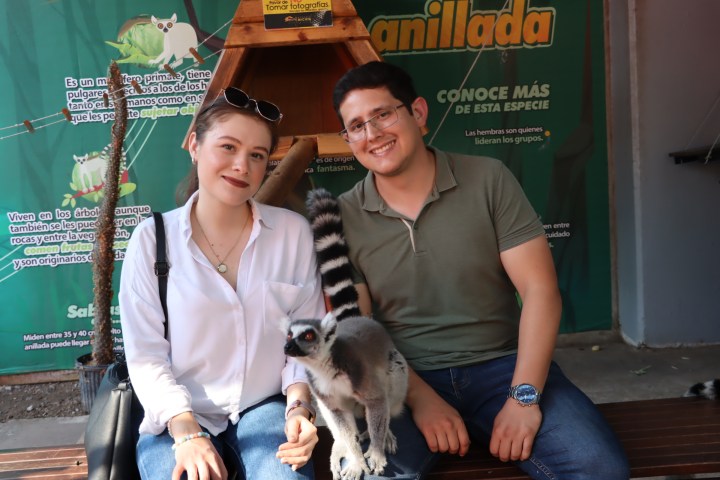 a person holding a dog posing for the camera