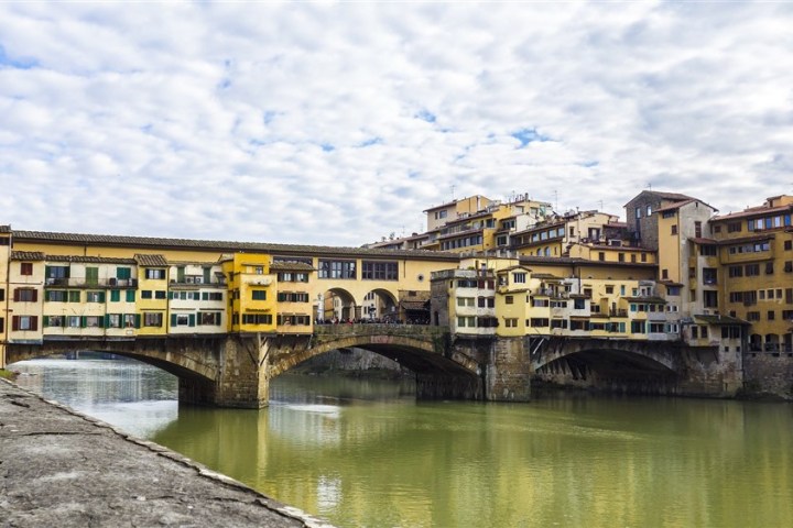 a train crossing Ponte Vecchio over a body of water