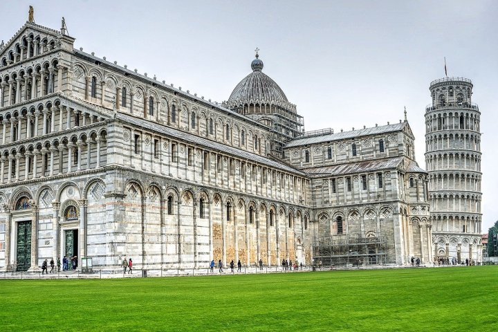 a large green field in front of Piazza dei Miracoli