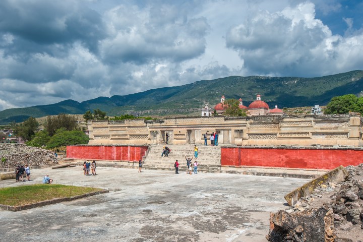 a group of people on a beach in front of a mountain