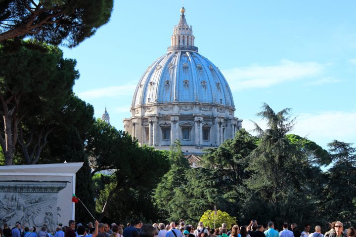 a group of people in front of a large building with a crowd watching