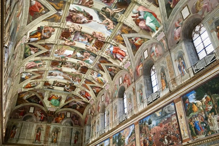 a large building with many windows with Sistine Chapel in the background