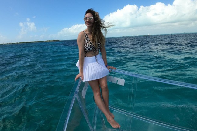 a woman standing next to a body of water