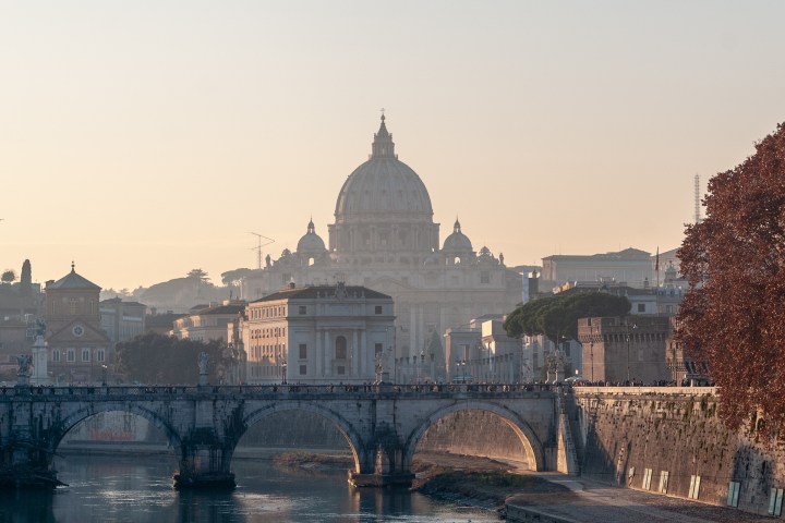 a bridge over water with a city in the background
