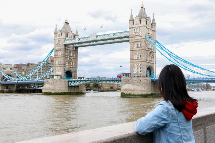 a person flying a kite in front of Tower Bridge