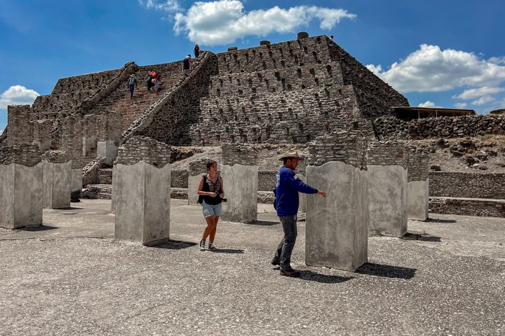 a man standing in front of a stone building