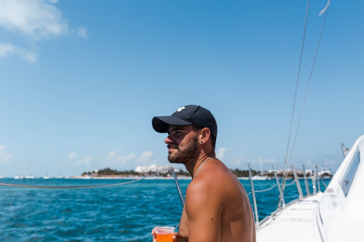 a man sitting next to a body of water