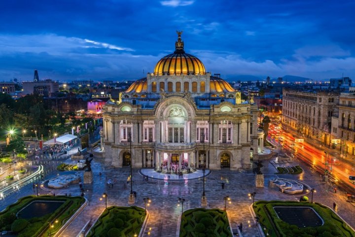 a large building in the background with Palacio de Bellas Artes in the background