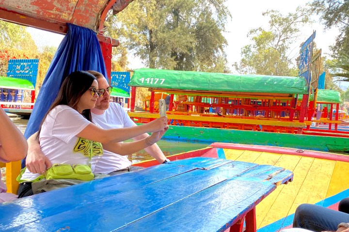 a group of people sitting at a table with a blue umbrella