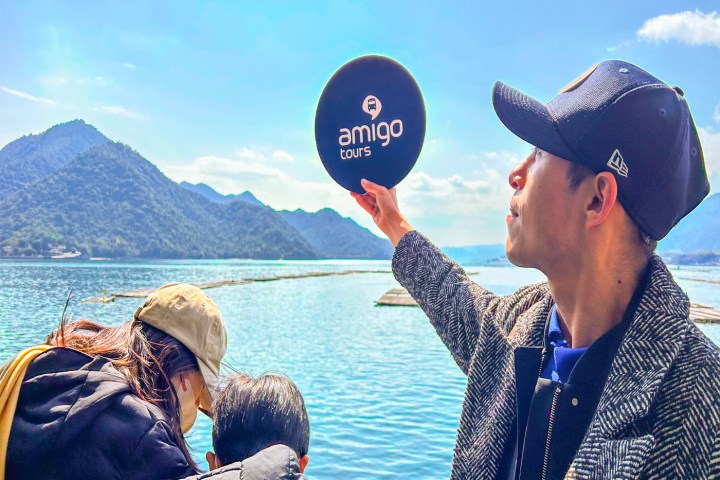 a man standing next to a body of water