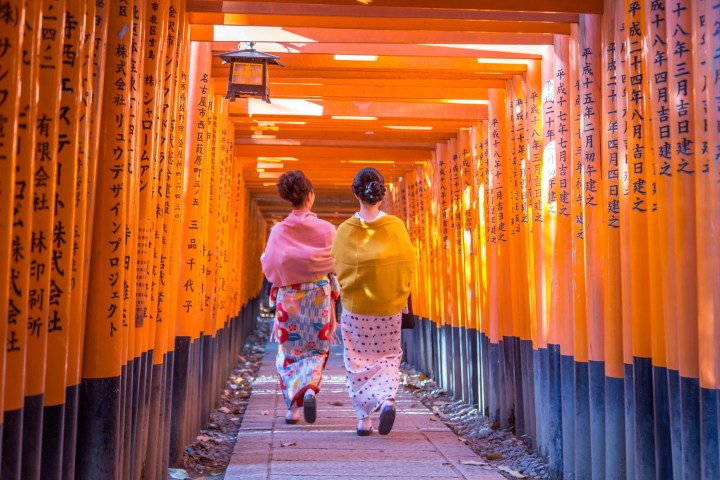 a man standing in front of a curtain with Fushimi Inari-taisha in the background