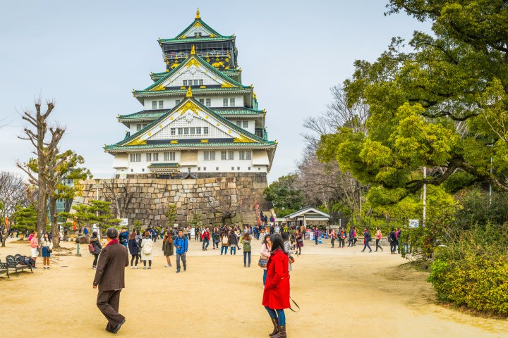 a group of people standing next to a clock tower