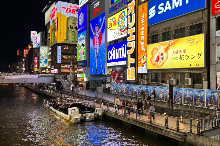 a bridge over water with a city in the background