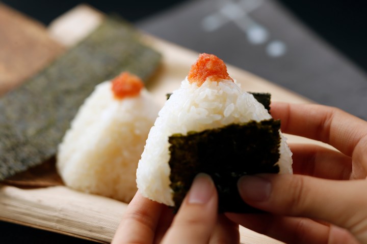 a hand holding a small piece of food