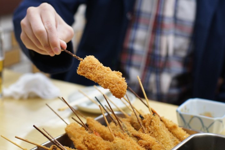 a person cutting a piece of cake on a plate