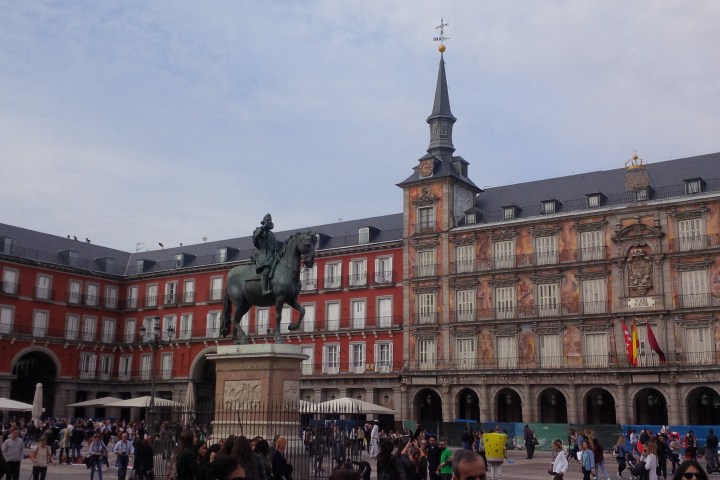 a group of people walking in front of Plaza Mayor, Madrid