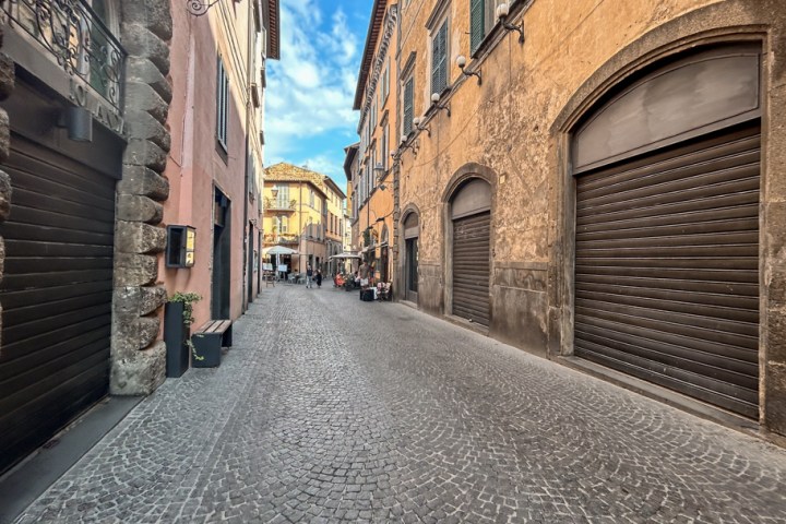 a large brick building with a clock on the side of a road