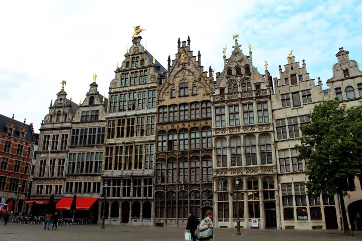 a group of people in front of a large building with Grand Place in the background
