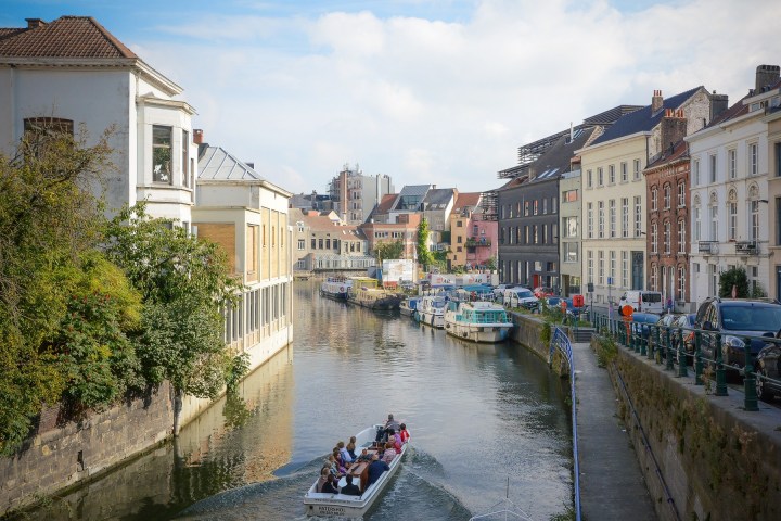a group of people walking down a street next to a river