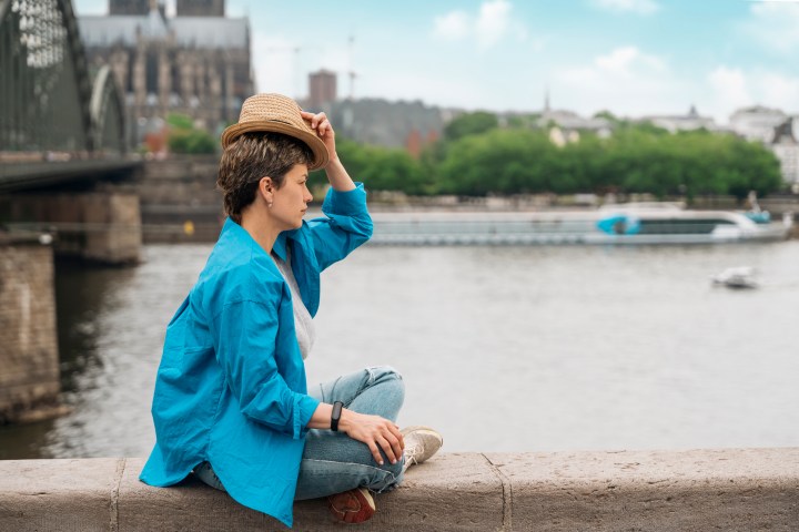 a young boy standing next to a body of water