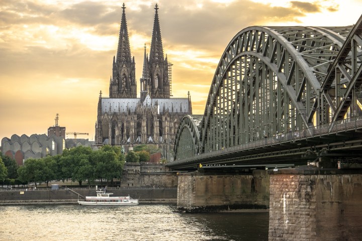 a large bridge over some water with Cologne Cathedral in the background