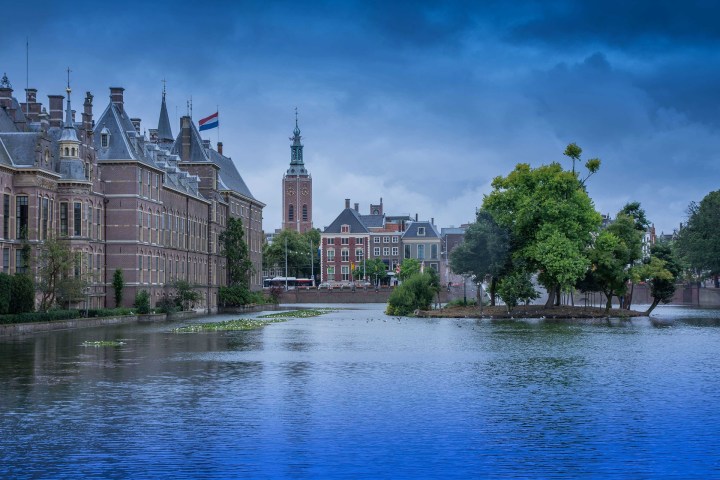 a castle with a clock tower next to a body of water