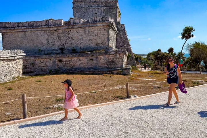 a little girl standing in front of a building