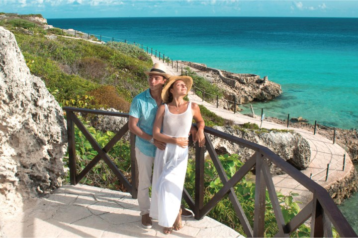 a person sitting on a rock near the ocean
