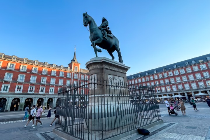 a group of people walking in front of Plaza Mayor, Madrid
