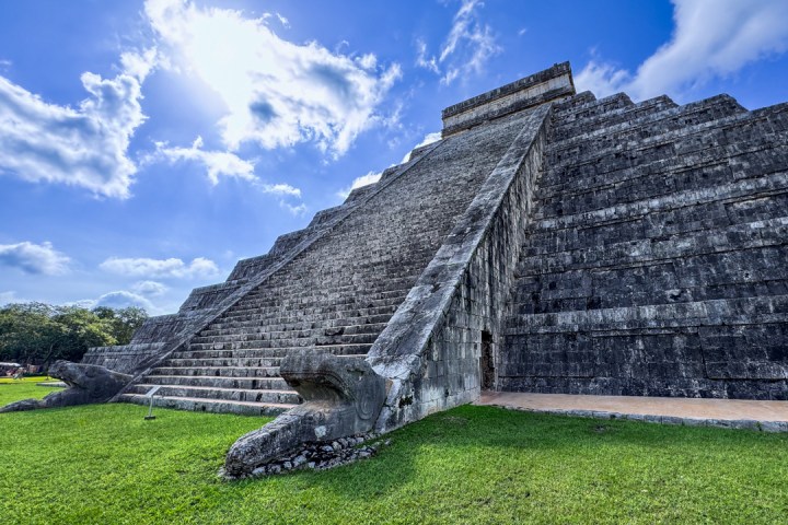 a large stone building with a grassy field